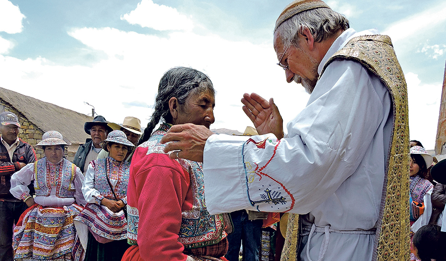 Eine Frau in traditioneller Tracht wird gesegnet.