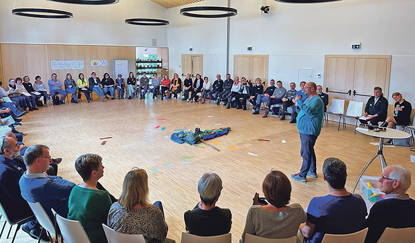 Pastoralvorstand Matthias List (stehend) erzählt von seinen Erfahrungen aus Linz-Urfahr.    