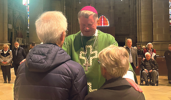 Ein Paar lässt sich von Bischof Manfred Scheuer segnen.  