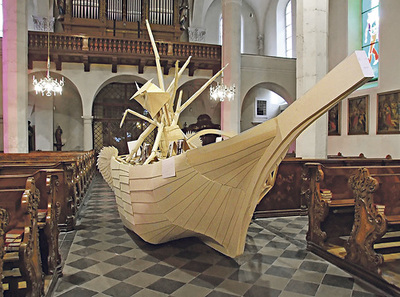 Kunst in der Kirche St. Andrä. Das Projekt „Narrenschiff“ thematisiert die Frage des Bleiberechts für Asylwerber/innen – mitten im Kirchenraum. Seit 1999 gibt es in St. Andrä das Bestreben, Kunst der Gegenwart viel Raum zu geben.
