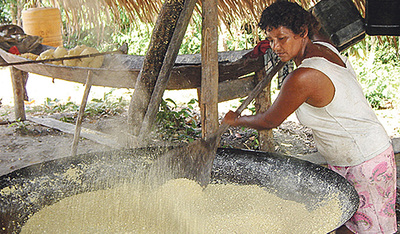 Eine Madihadeni verarbeitet Maniok zu Mehl. 