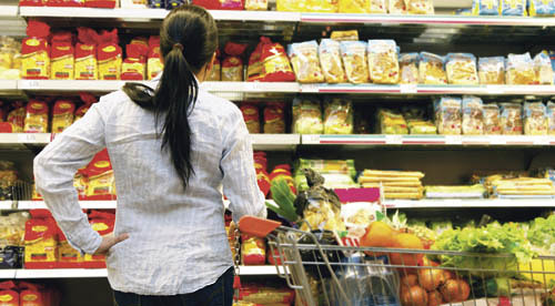 Junge Frau steht vor Regal in einem Supermarkt