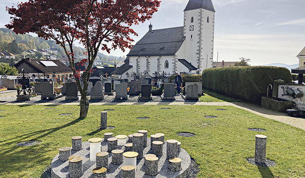 Neu: ein Urnengarten in Grünbach bei Freistadt. Der „Gedenkort für alle“ lädt zum Verweilen auf dem Friedhof ein: Die Zylinder im runden Feld sind Gedenksteine. Wird eine Urne in der Erde beigesetzt, markiert der Gedenkstein die Grabstelle. Die Blume