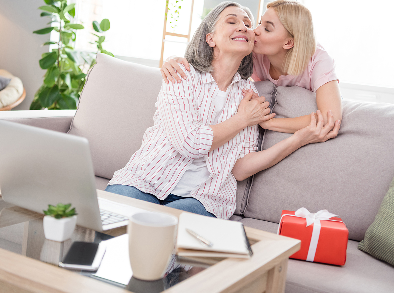 Photo of cheerful positive family daughter kiss mom good mood gift women day indoors inside house home.