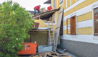 Bauarbeiten tragen die alte Garage ab, um Platz für eine Fluchtstiege zu schaffen. 