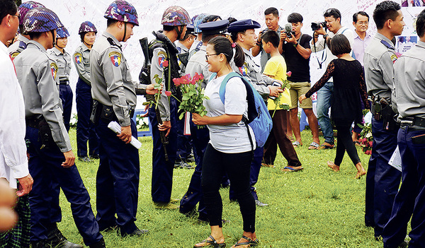 Friedensfachkräfte setzen sich in Krisengebieten für ein friedliches, gewaltloses Leben der Menschen vor Ort ein. Hier verteilt eine Demonstrantin in Myanmar Rosen an Soldaten.  