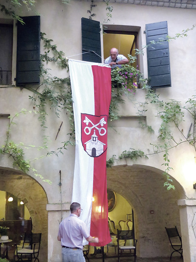 Pfarrer und Bürgermeister hissen im Sommer 2019 die Bad Zeller Fahne in Pordenone in Friaul-Julisch Venetien. Gemeinsame Reisen von Gemeinde und Pfarre sind Tradition in Bad Zell.  
