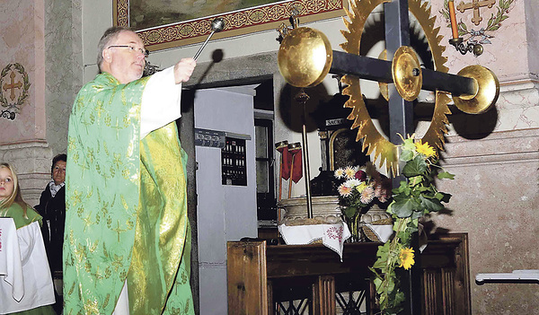 Generalvikar Severin Lederhilger segnet das Turmkreuz.  