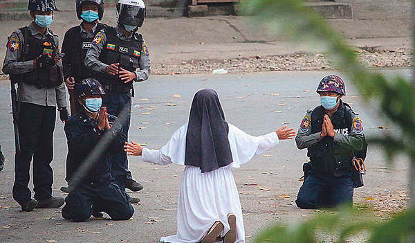Auf Knien bittet die katholische Ordensfrau Ann Rose Nu Tawng bewaffnete Polizisten in Myanmar, keine Gewalt gegen Demonstranten anzuwenden. 