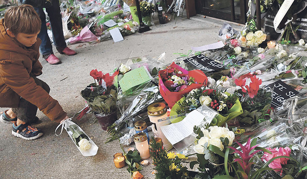 Vor dem Eingang der Schule in Conflans-Sainte-Honorine legen Trauernde Blumen für den getöteten Lehrer nieder.