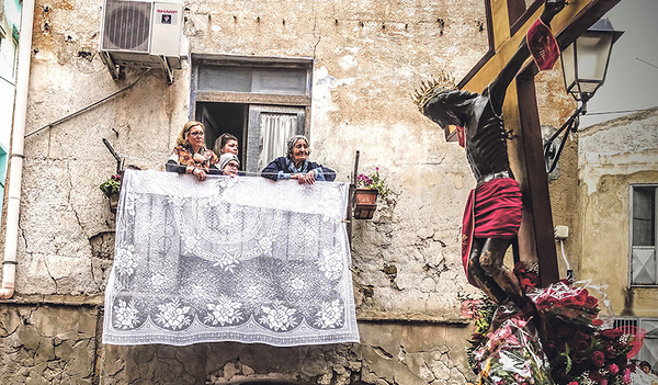 Flüchtlinge beobachten die Prozession des Schwarzen Jesus: Der Film zeigt, wie sich Flüchtlinge und Einheimischen in Sizilien einander annähern. Jahrhundertealtes Brauchtum wird damit in die Gegenwart geholt. 