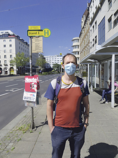 Warten auf den Bus. Ich warte (gemeinsam mit meiner Frau und meinen Kindern) bei der Haltestelle mit der für den öffentlichen Verkehr verpflichtenden Gesichtsmaske.