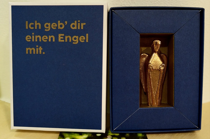 Blauer Karton worin der Bronze-Engel verpackt ist.