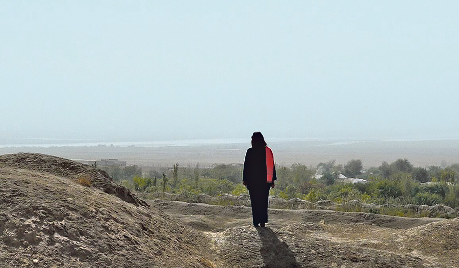 Manizha Bakhtari blickt nachdenklich über die Grenzen in ihr Heimatland Afghanistan. Dorthin reisen kann sie nicht, solange die Taliban in Kabul an der Macht sind. Szene aus dem Film „Die letzte Botschafterin“.  