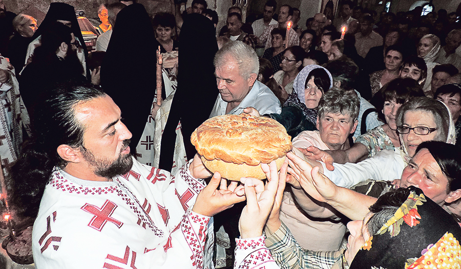 Der „Slavski Kolač“, ein Festtagskuchen, wird von dem serbisch-orthodoxen Priester und dem Volk gehalten und mit kleinen Bewegungen ­gedreht – Zeichen der Einheit und der Ewigkeit (Kloster Krupa, Kroatien).
