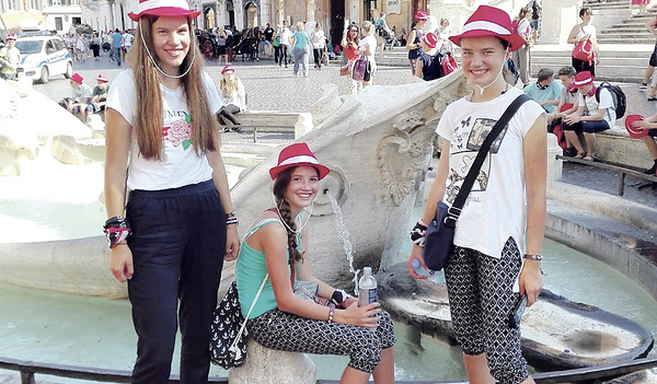 Drei Ministrantinnen aus Oberneukirchen stärken sich bei einem Brunnen an der Spanischen Treppe.