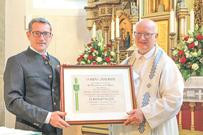 Bürgermeister Harald Grubmair überreichte die Ehrenbürgerurkunde feierlich an Pfarrer Josef Etzlstorfer.    