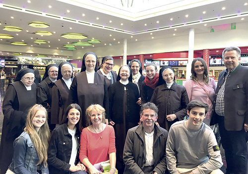 Pfarrer Heinz Purrer (2. von rechts, kniend) und Bürgermeister Mair (rechts) mit Kinobesucher/innen und -besuchern.  