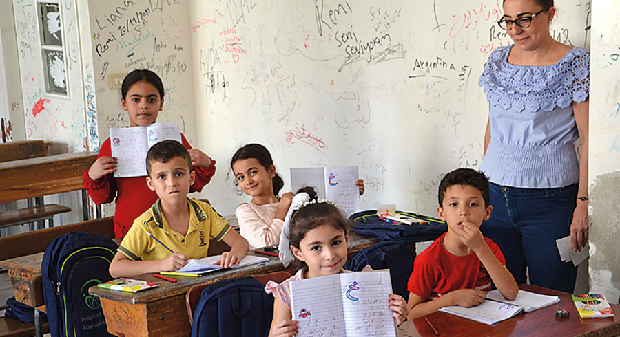 Die jungen Schülerinnen zeigen stolz ihre Schreibhefte. Das Schulprojekt in Damaskus wird von ICO unterstützt. 