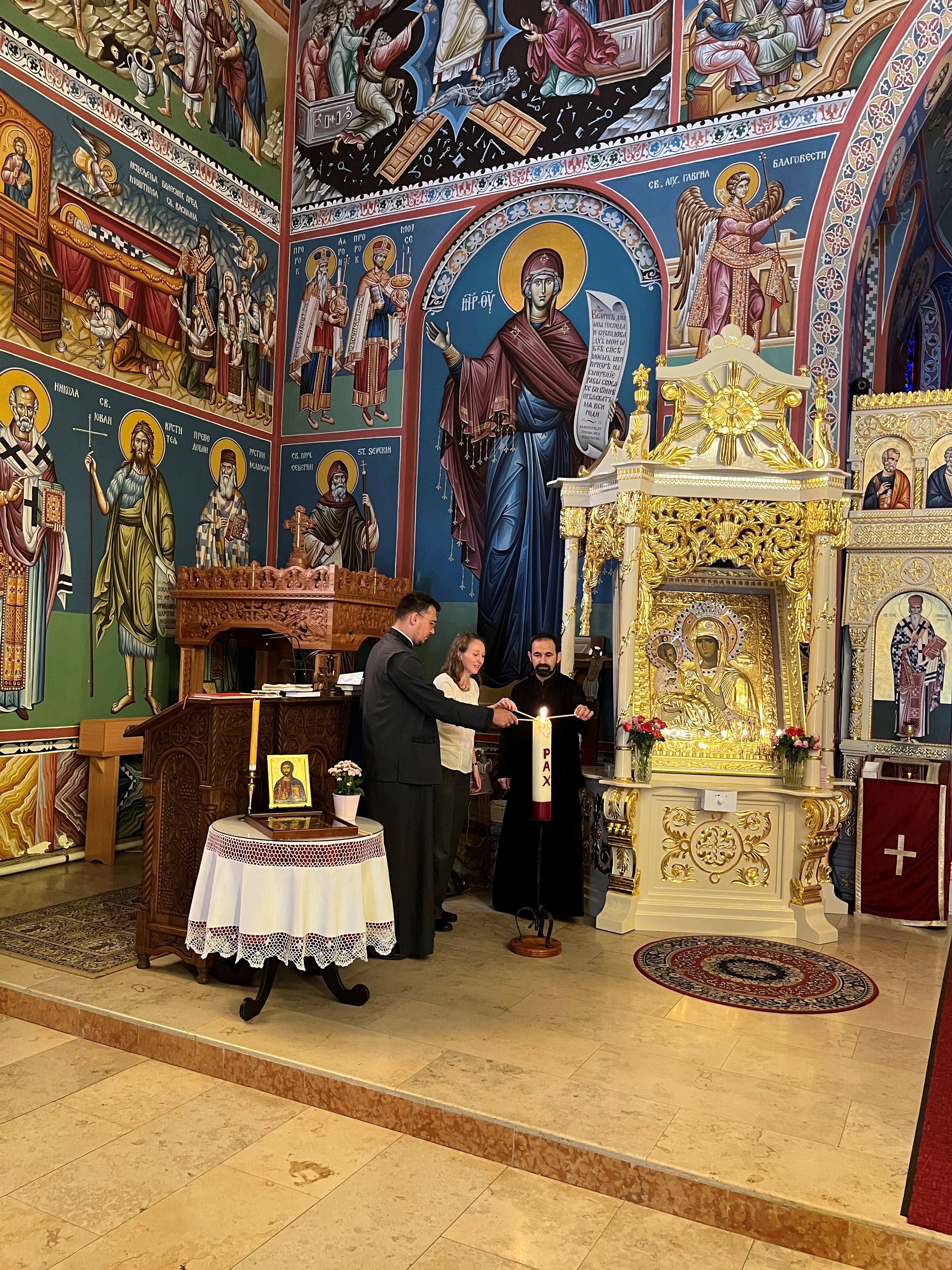 privat Diakon Nemanja Micic, Ökumene-Referentin Gudrun Becker und Prieser Zoran Vrbaski entzünden zusammen die Friedenskerze