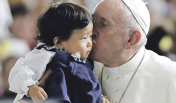 Vor einer Messe im Tokyo-Dome-Stadion in Tokio küsst Franziskus ein Kind. 