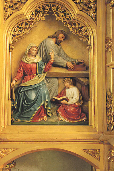 Idylle. So stellte sich das 19. Jahrhundert den Alltag der heiligen Familie vor: Josef arbeitet als Zimmermann, Maria spinnt und Jesus liest (Josefs­altar der Stadtpfarrkirche Traun).