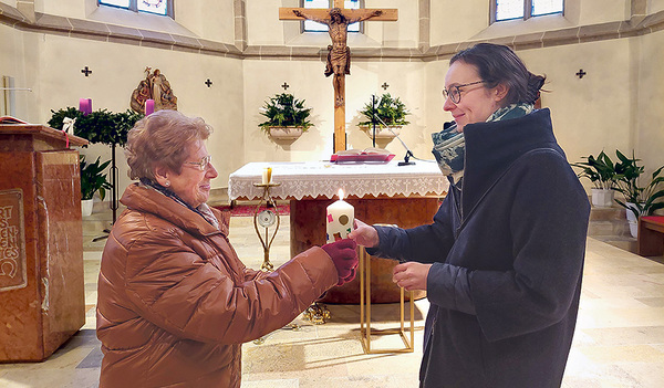 Pfarrgemeinderätin Regina Reiter, Initiatorin des Projekts (re.), übergibt eine Kerze.     
