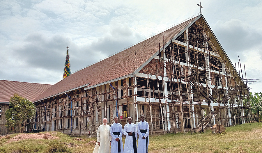 Die sich in Bau befindliche Kirche von Nyaishozi im Osten Tansanias. Davor Pfarrer Hans Humer mit Priesterseminaristen, die bei ihm in den Ferien mitarbeiteten.   