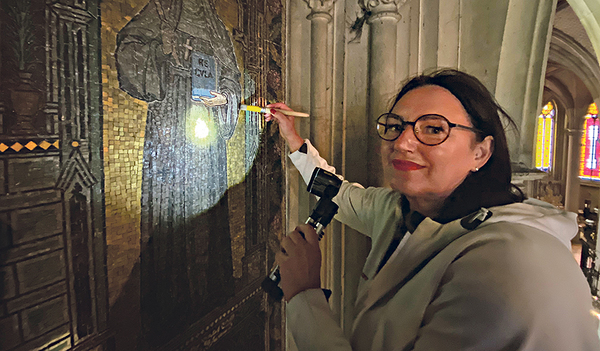 Restauratorin Susanne Beseler vor den Glasmosaiken an der Wand, die bis zu 12 Meter hoch sind und nur mit einem Hubsteiger erreicht werden können.