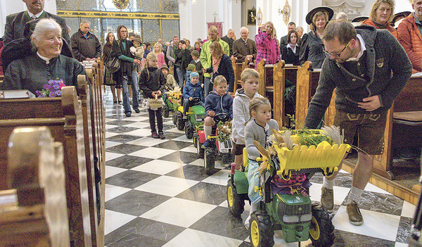 Die Kinder mit ihren festlich geschmückten Spielzeugtraktoren.  