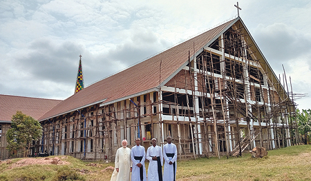 Die sich in Bau befindliche Kirche von Nyaishozi im Osten Tansanias. Davor Pfarrer Hans Humer mit Priesterseminaristen, die bei ihm in den Ferien mitarbeiteten.   