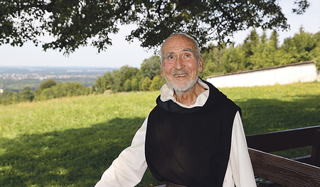 David Steindl-Rast unter einem Baum auf einer Wiese. 