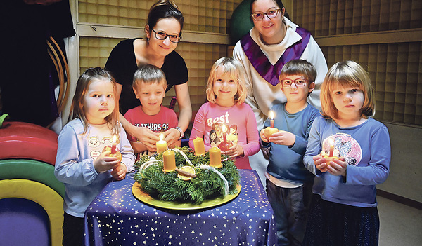 Mit der Adventkranzsegnung wird die Zeit des Wartens auf das Geburtstagsfest von Jesus im Kindergarten eröffnet (v. l. n. r.): Emma, Georg, Iris, Tobias und Carmen mit Julia Gstöttenbauer (Pädagogin) und Katharina Kern (Pastoralassistentin).   