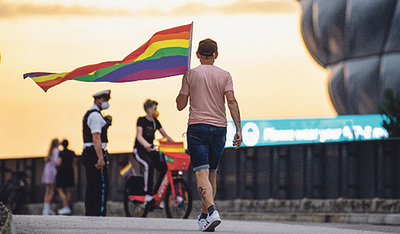 Ein Fan schwingt die Regenbogenfahne. 