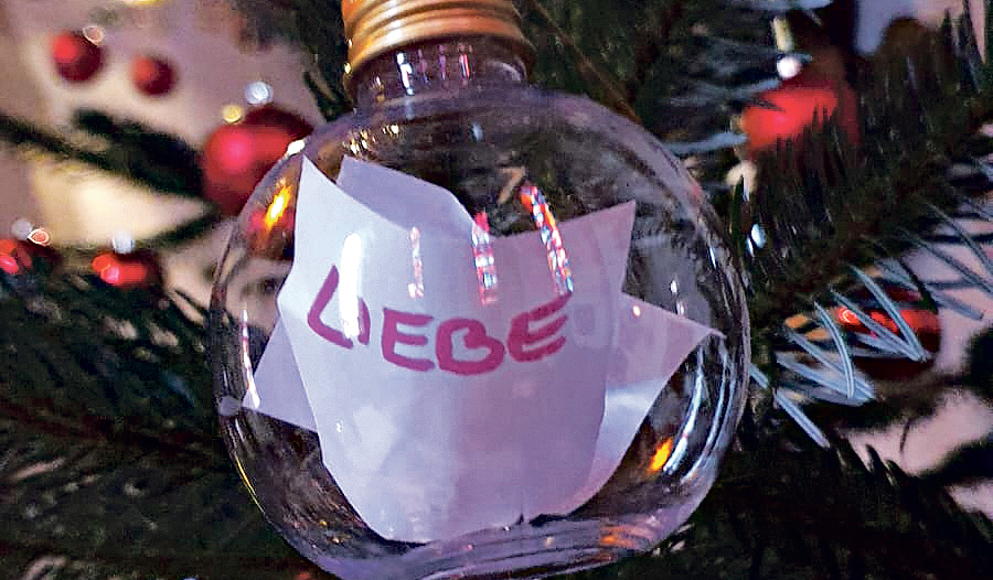 Die Kugeln sind mit Wörtern beschriftet, die Menschen mit  Weihnachten verbinden.  