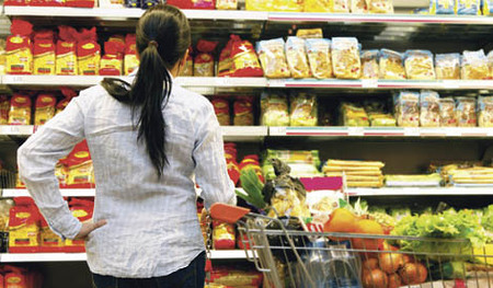 Junge Frau steht vor Regal in einem Supermarkt