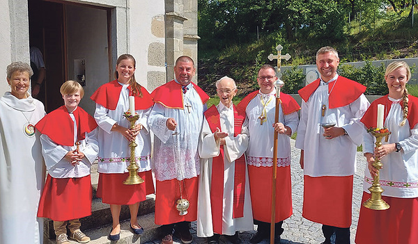 Pfarrer Haslinger inmitten von Ministrant/innen 