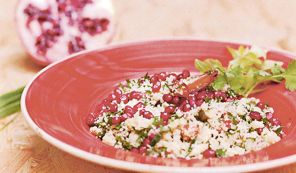 Granatapfelkerne, Pistazien und Datteln verfeinern diesen Couscous-Kräutersalat.  