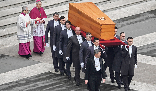 Sargträger mit Holzsarg von Papst Benedikt XVI., rechts dahinter Erzbischof Georg Gänswein.   