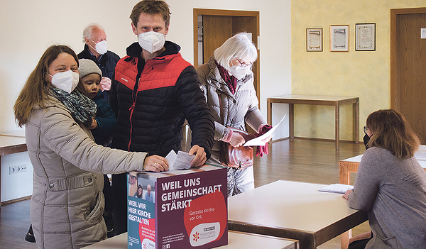 Eine junge Familie bei der Wahl in der Stadtpfarre Braunau.  