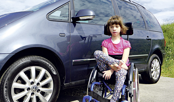 Lily vor dem Auto. Es ist groß genug, damit ihre Mutter sie leichter hineinsetzen kann.   