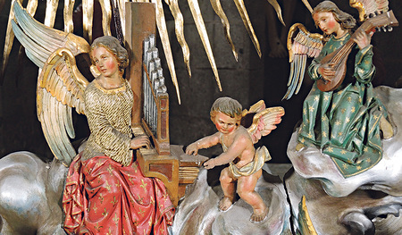 Der orgelspielende Engel ist eine der 42 Figuren im Strahlenkranz (Gloriole) der Domkrippe. Ein kleines Engerl betätigt den Blasebalg.  Der Krippenkünstler Sebastian Osterrieder hat alle Figuren mit viel Liebe zum Detail gestaltet. 