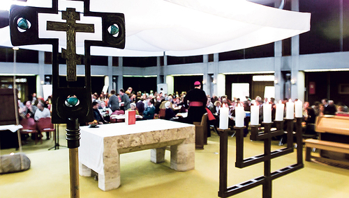 Kreuz und Menorah (Siebenarmiger Leuchter) im Altarraum einer katholischen Kirche als Sinnbild dafür, dass der „Alte Bund“ mit dem Volk Israel nicht aufgekündigt ist und weiter seine Gültigkeit hat.