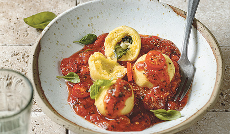 Auf Tomatenragout angerichtet schmecken die Basilikum-Käseknödel vorzüglich.