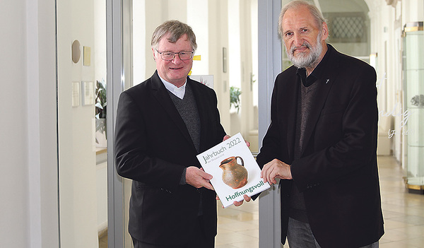 Jahrbuch-Herausgeber Wilhelm Vieböck (re.) überreicht Bischof Manfred Scheuer das neue Jahrbuch.