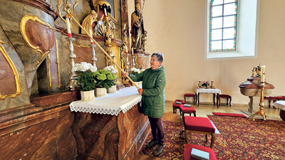 Eine klassische Aufgabe einer Mesnerin: Rosa Hain beim Löschen der Kerzen in der Pfarrkirche.  