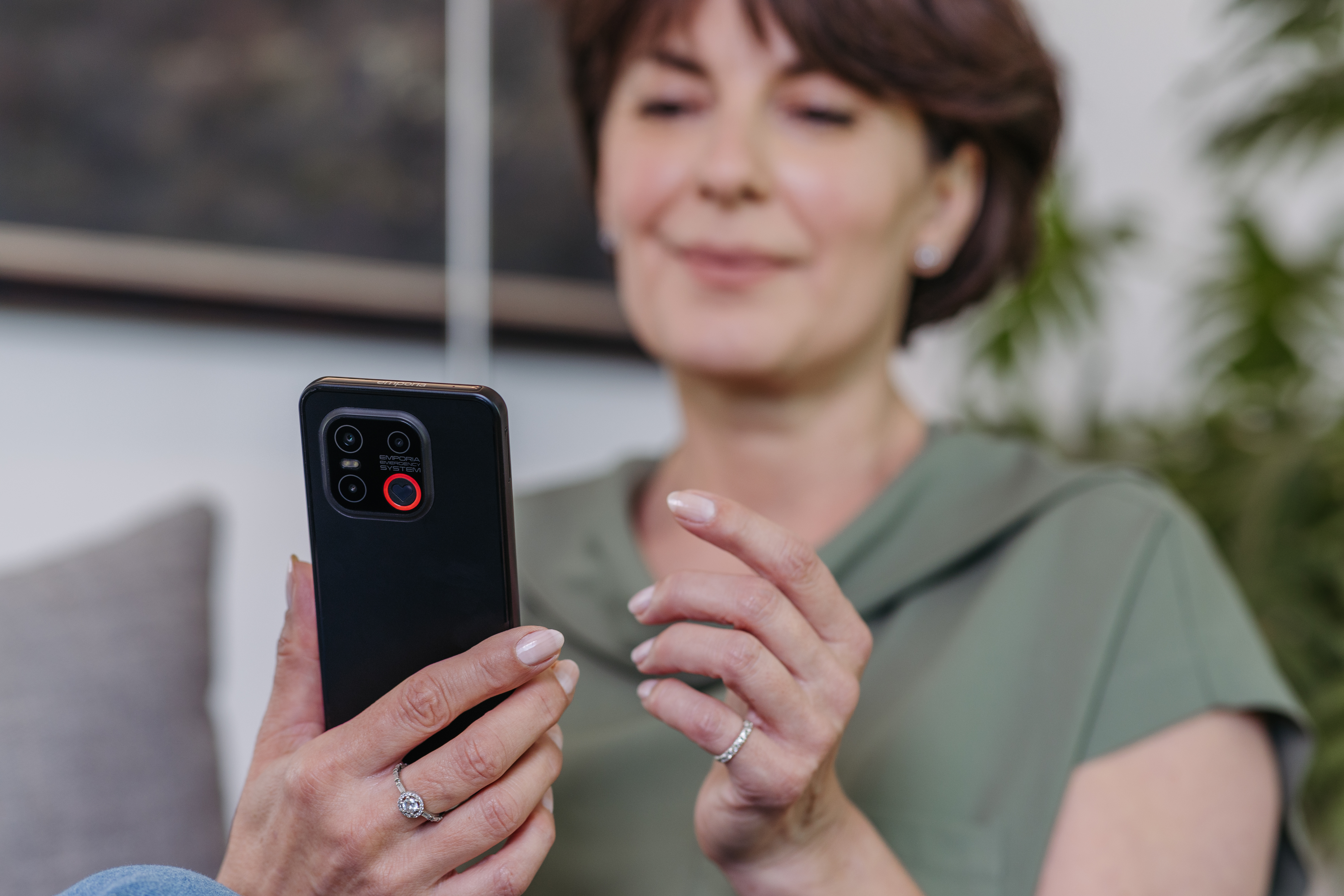 Frau mit empoira Smartphones mit Google Sprachassistent auf Knopfdruck