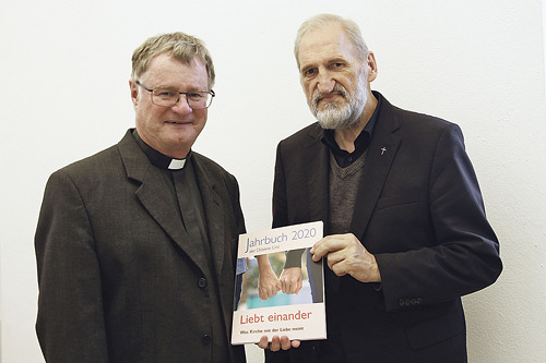 Bischof Manfred Scheuer erhält das neue Jahrbuch von Herausgeber Bischofsvikar Willi Vieböck. 