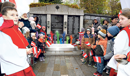 Eine Kinderschar vor dem neu errichteten, bunten Friedensdenkmal.   