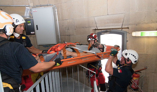 Die Person wird bei der Übung von den speziell ausgebildeten Höhenrettern der Berufsfeuerwehr außen am Turm abgeseilt.